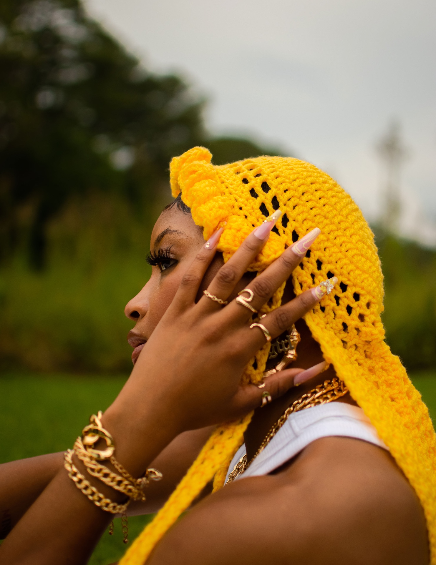 Side profile editorial shot wearing a yellow knitted headpiece